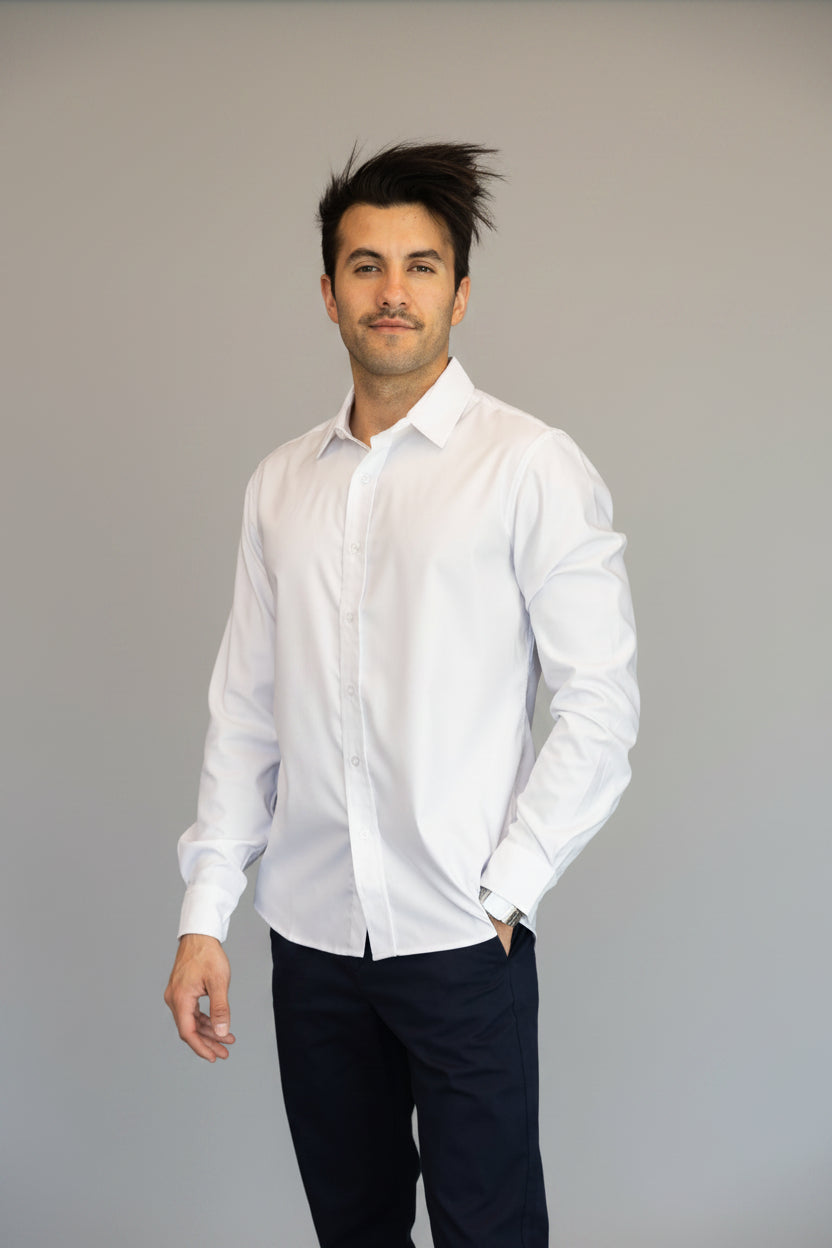 Man wearing a white shirt and dark pants against a grey background