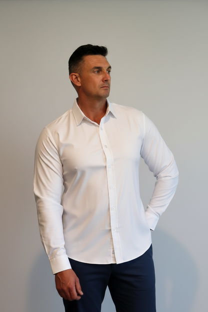 Man wearing a white shirt standing against a geometric wall design