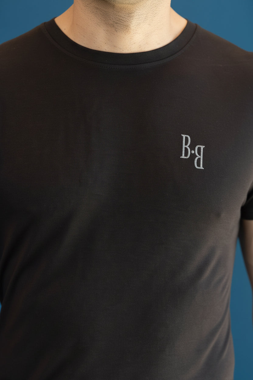 B.Balanced Co black bamboo blend crew neck t-shirt with small logo detail on chest worn by a man