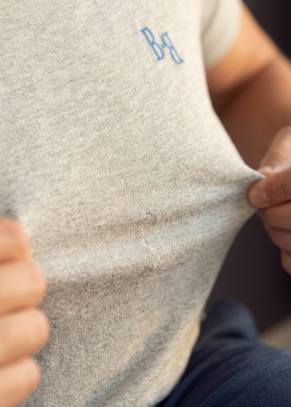 B.Balanced Co heathered grey crew neck t-shirt with blue chest logo, showing soft-touch fabric stretch and texture.